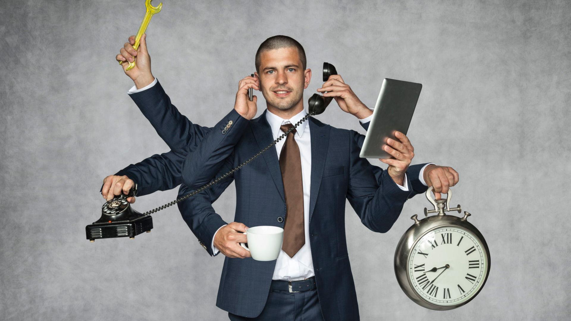 Business Man Multi-Tasking With Clock Practising Good Time Management Skills