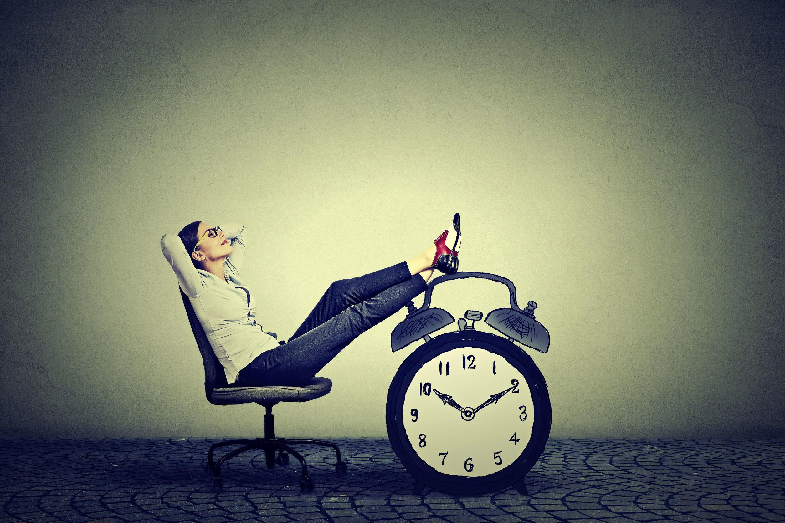 Business Woman Relaxing In A Chair With Her Feet Up On A Clock