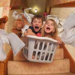 Kids In Washing Basket Having Fun Flying Down The Stairs