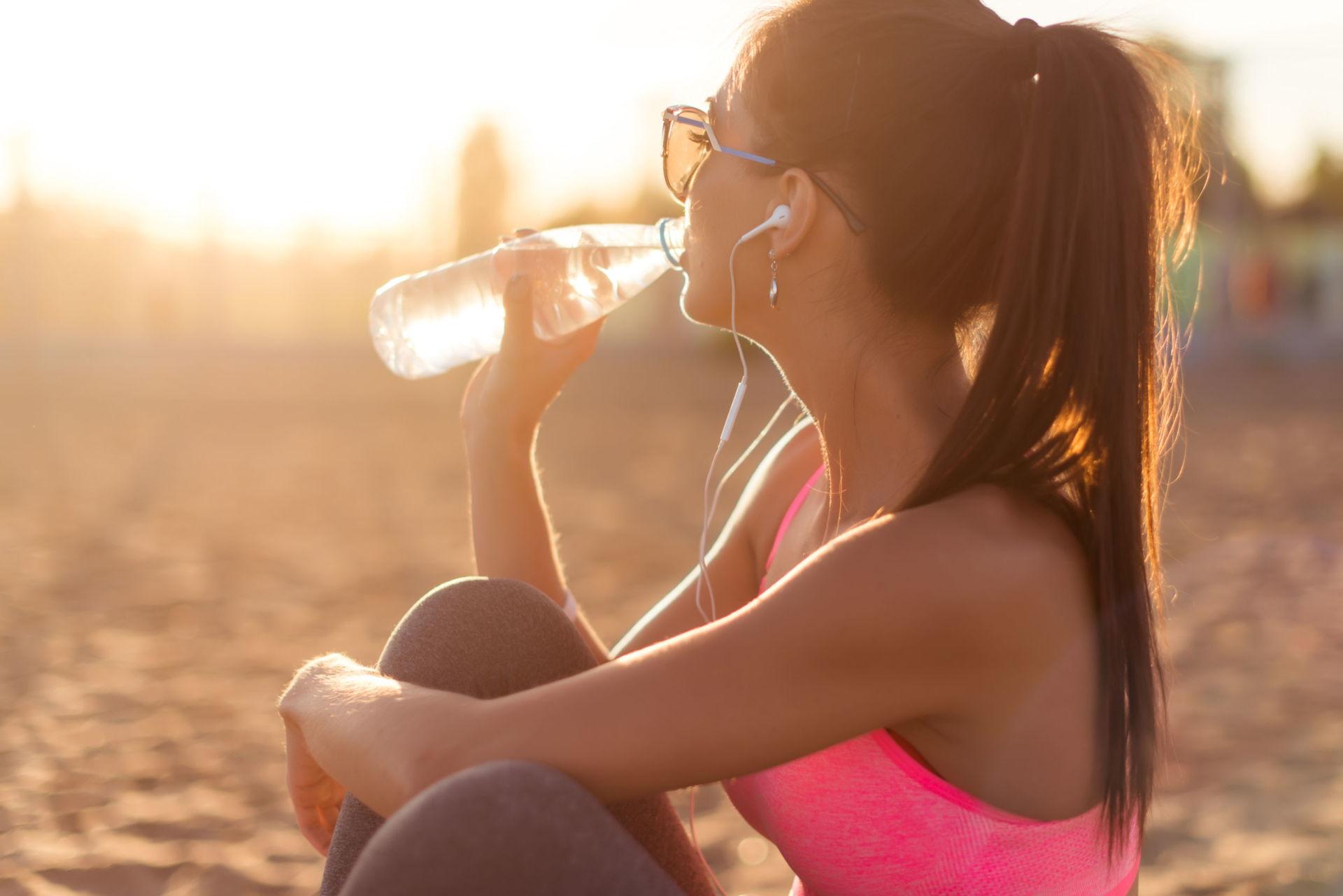 Woman Drinking Water After A Workout