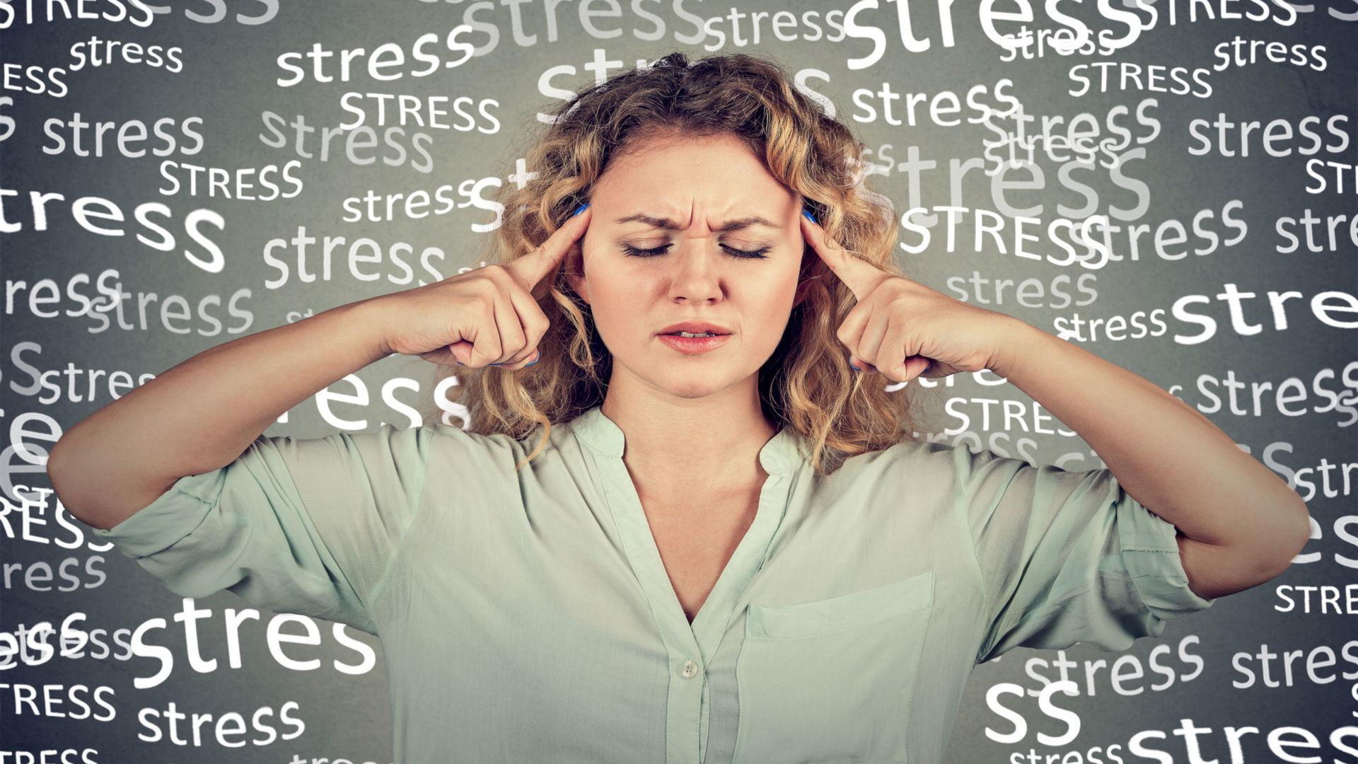 oung Woman Looking Stressed With The Word Stress Written Behind Her